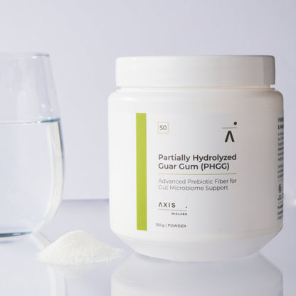 A white plastic jar of AXIS BioLabs Partially Hydrolyzed Guar Gum (PHGG) powder, shown on a reflective white surface with a glass of water and a small pile of the prebiotic powder on the left.